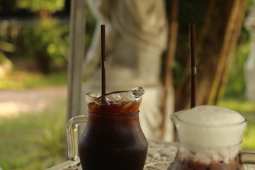 Americano coffee in a glass on the table in a cafe in the garden