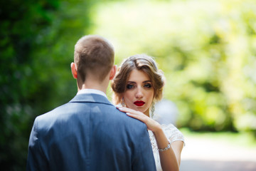 Obraz premium Bride and groom on their wedding day, walking outdoors in nature.