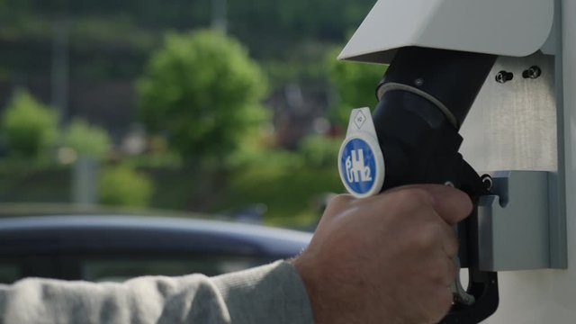 Hydrogen Pump at gas station with hydrogen car in background