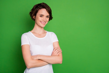 Photo of attractive lady short curly hairdo arms crossed bossy person self-confident worker company representative wear casual white t-shirt isolated green color background