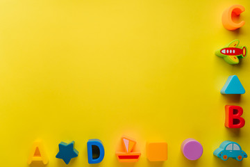 Top view on children s toys on a yellow background. Children's toys on the table. concept for advertising toys for children. Copy space children's toy.