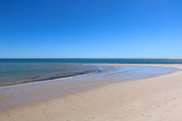 Fototapeta na wymiar Simple, clean, minimal view of a beach and ocean shore on a summer day. Algarve, Portugal.