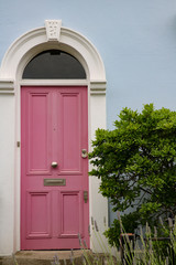 Pink front door to a Victorian terrace house in central London, United Kingdom.