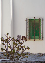 Beautiful traditional whitewashed facade of Greek house in small and narrow alley or street in...