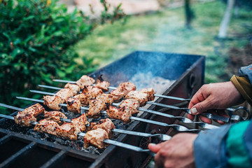 a man fries kebabs on the grill in his infield.