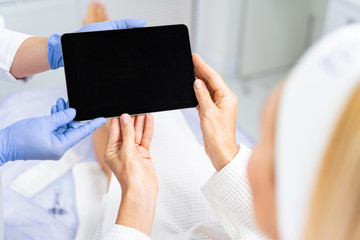 Two pairs of women hands holding a tablet computer