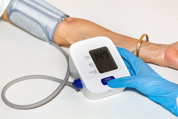 Medical examiner use portable monitoring device to measure blood pressure and heart rate of female...
