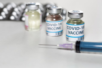 Vaccine bottles with injection syringe and medicine in selective focus for treatment of coronavirus patients