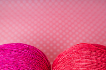 skein of pink thread for knitting on a pink background