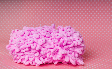 skein of pink thread for knitting on a pink background