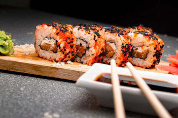Orange rolls with black sesame seeds. Wood surface. Photo for the menu