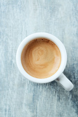 Cup of coffee on bright wooden background. Top view. 