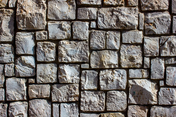 grey old  stone wall composed of natural material, background with architectural elements