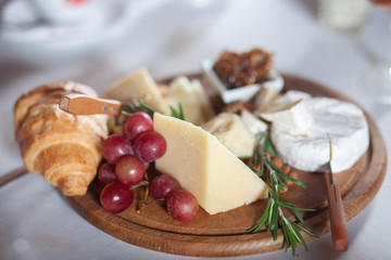 cheese plate on a wooden stand, which stands on a table