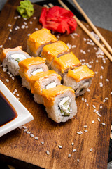 Rolls with curd and cream cheese. Wooden tray. Cup with soy sauce