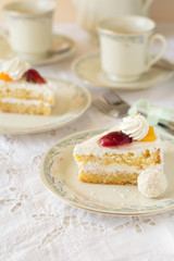 Slice of cake with cream and fruits on white background. Tea time. Selective focus