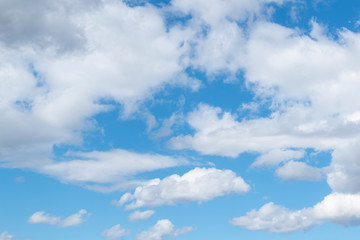Naklejka na ściany i meble White fluffy clouds on a bright blue sky.