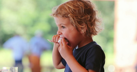 Fototapeta premium Child eating melong fruit dessert with spoon