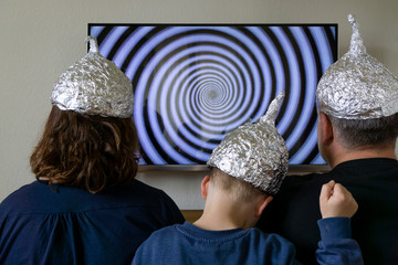 Family with Tin foil hat in front of TV