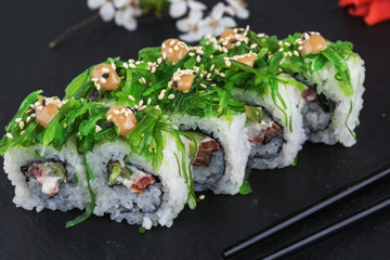 Sushi rolls with seafood and Chuka salad. Green sushi. Top view. Free space for your text.