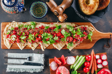 Lula Kebab on the wooden service plank with garnet and arabic bread