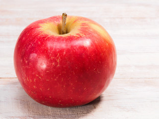 Ripe red apple on a light brown wooden background. Healthy eating concept