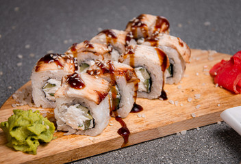 Smoked eel rolls on a wooden stand. Photo for the menu.