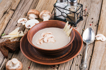 Cream soup with mushrooms champignon on wooden boards