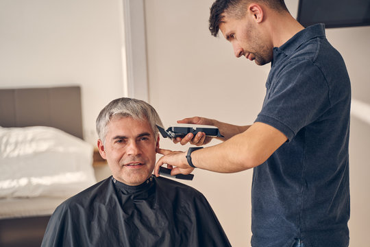 Male client getting haircut by hairdresser at home