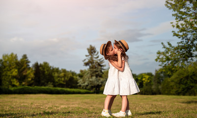 Obraz premium Twins kissing in summer park