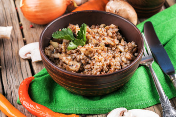 Buckwheat porridge with mushrooms in the frying pan on the table