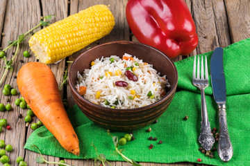 A plate of rice with vegetables on wooden boards