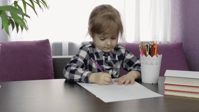 Cute child girl studying drawing picture with pencil at home. Distance education