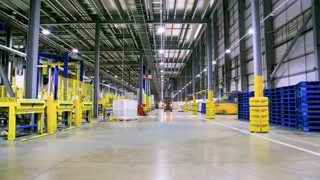 Bright Yellow and Blue Machines and Forklifts inside Warehouse / Timelapse