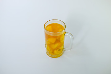 a glass of Kolak isolated on white background. Kolak is an Indonesian dessert based on palm sugar or coconut sugar, coconut milk, and pandanus leaf contains banana and pumpkins or sweet potatoes,