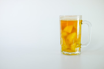 a glass of Kolak isolated on white background. Kolak is an Indonesian dessert based on palm sugar or coconut sugar, coconut milk, and pandanus leaf contains banana and pumpkins or sweet potatoes,