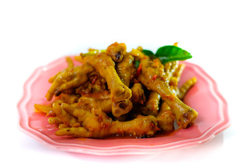 Asian food spicy chicken feet, served with a green plate isolated from a white background