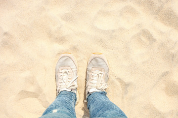 Fototapeta premium Female legs in jeans and sneakers