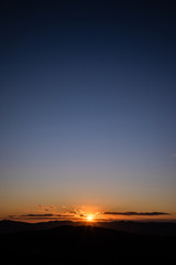 Beautiful sunset with sun rays with hills silhouette