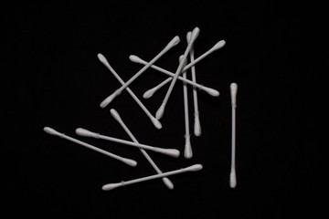 Top down image of ear buds scattered in a dark copy space background. Object photography.