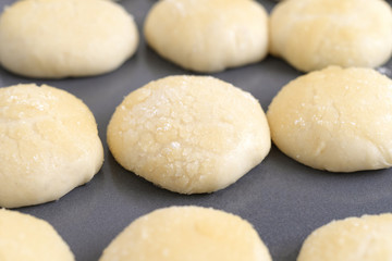 Fototapeta na wymiar Raw buns on a tray. Cooking buns at home