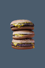 Three hamburgers on the grey background. Fast food concept. Copy space. Place for text and design.