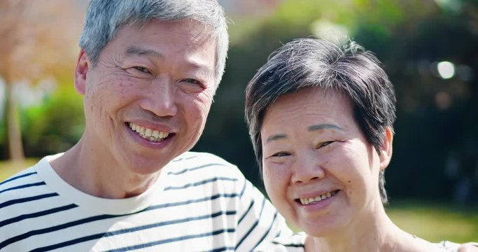 Asian elderly couple smile at you
