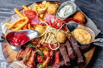 Assorted fried beer snacks: spicy chicken wings, chechil cheese,
potato croquettes, croutons, suluguni in puff pastry, spring rolls from chicken with vegetables, chorizo sausage, french fries.