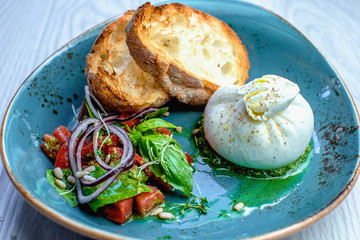 Stratagella cream cheese with cherry tomatoes, arugula, pesto, bread and balsamic cream