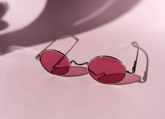 Pink sunglasses on the pink background. Minimal summer concept. Copy space.Place for text and design.