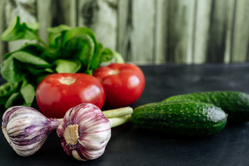 Still life of fresh vegetables. Own crop for healthy eating. Cucumbers Tomatoes Garlic Spinach.