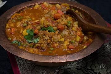 Indian mixed vegetable curry in copper bowl