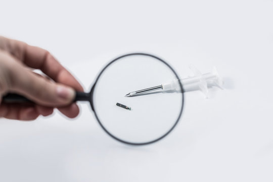 syringe with a microchip on a light background, nobody, close up