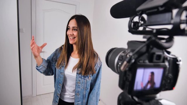 Happy young woman blogger filming new vlog video with professional camera at home slow motion.